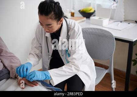 Arzt führt IV-Katheter ein, um dem Patienten Medikamente oder Flüssigkeiten zu verabreichen Stockfoto