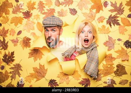 Überrascht Paar auf Herbst Kleidung Rabatte, Mann mit Bart und ein attraktives Mädchen in gelbem Hintergrund. Herbstpaar trägt im Herbst Kleidung Stockfoto
