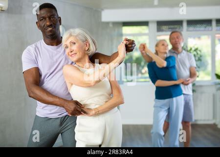 Gruppe multiethnischer Erwachsener, die Gesellschaftstanz tanzt Stockfoto