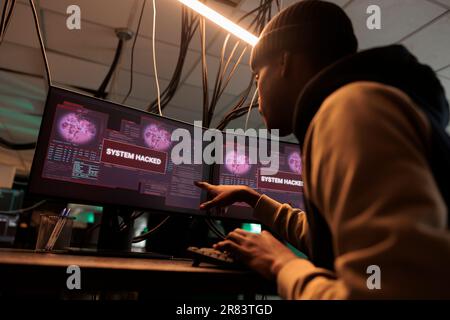 Cyberkriminelle Pflanzen Malware mit Viren aus und arbeiten an Phishing-Technologie. Junge Hacker greifen auf das Datenbanksystem zu, knacken die Verschlüsselung des Serverschutzes. Cybersicherheit, Konzept des Datendiebstahls. Stockfoto