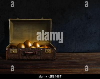 Goldene Eier in einem alten Koffer Stockfoto