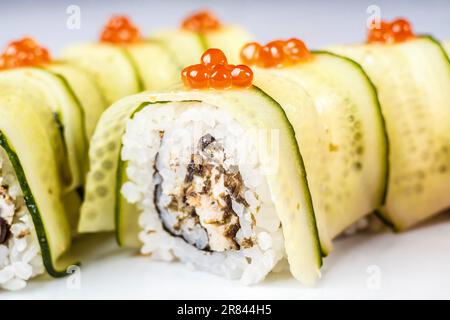 Ein farbenfrohes kalifornisches Brötchen mit frischen Produkten und Meeresfrüchten wie Gurken und rotem Kaviar für ein gesundes und köstliches Sushi-Gericht. Stockfoto