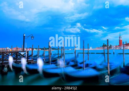 Venedig-Gondeln bei Langzeitanwendung. Traditionelle Boote, die in Venedig vor Anker liegen Stockfoto