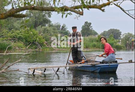 Schwedt, Deutschland. 19. Juni 2023. Hannah Neumann (Bündnis 90/die Grünen, r), Mitglied des Europäischen Parlaments, sitzt mit dem Fischer Helmut Zahn auf einer Testfischereifahrt auf der Schwedter Querfahrt an der deutsch-polnischen Grenze der oder im Nationalpark des unteren oder-Tals in einem Kahn. Fast ein Jahr nach der verheerenden Umweltkatastrophe und ihrer ersten Reise in die oder ist die Abgeordnete Neumann wieder auf Tour entlang des Flusses. Am selben Tag fand eine Probefischung an der Kreuzung Schwedt auf der oder im Nationalpark Lower oder Valley statt. Kredit: Patrick Pleul/dpa/Alamy Live News Stockfoto