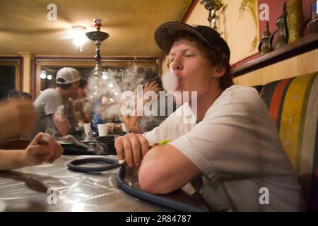 Ein junger Mann raucht Wasserpfeife in Zaina in Downtown Seattle, Washington. Stockfoto