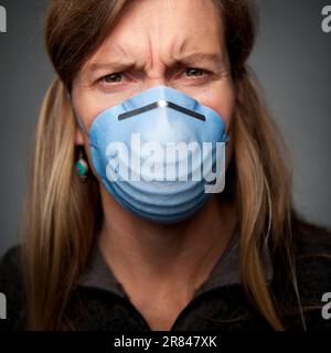 Studio Nahaufnahme Porträt einer 49 Jahre alten blonden kaukasischen Frau, die eine medizinische Maske trägt. Stockfoto