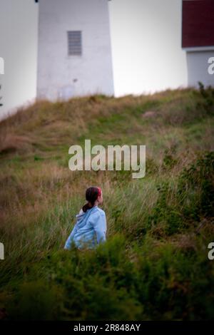 Ein junges Mädchen spielt während ihres jährlichen Familienurlaubs auf Swans Island, Maine. Stockfoto