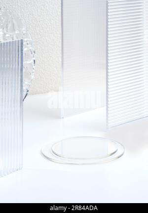 Transparentfolien-Sockelprodukte zeigen einen weißen Hintergrund mit hohem Tastendruck auf modernem Transparentfolien-Glas mit Sonnenlicht an Stockfoto
