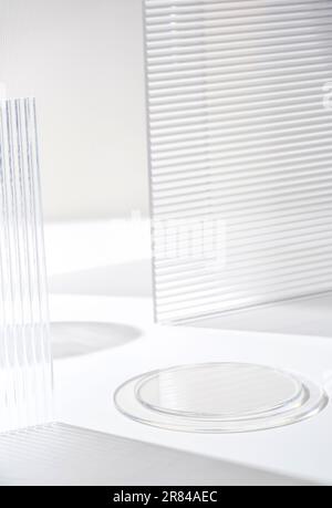 Transparentfolien-Sockelprodukte zeigen einen weißen Hintergrund mit hohem Tastendruck auf modernem Transparentfolien-Glas mit Sonnenlicht an Stockfoto