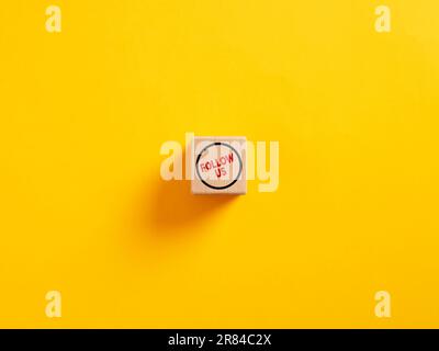 Folgen Sie uns auf einem hölzernen Würfel. Das Konzept der Anziehung von Followern aus sozialen Medien oder dem Internet. Stockfoto