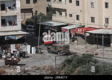 Jenin, Palau. 19. Juni 2023. Eine Ambulanz des Palästinensischen Rothalbmond fährt inmitten von Zusammenstößen zwischen israelischen Streitkräften und Palästinensern während einer groß angelegten israelischen Militäroperation in der besetzten Stadt Dschenin im Westjordanland. Mindestens drei Palästinenser wurden getötet, so die palästinensischen Gesundheitsbehörden am frühen Montag. Kredit: Ayman Nobani/dpa/Alamy Live News Stockfoto