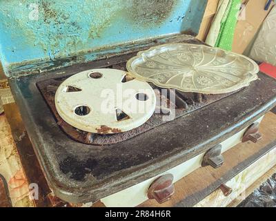 Ein alter Gasherd zum Kochen. Brenner für Benzin, Pfannen. Zwei Orte zum Kochen. Gartengeräte für die Küche. Kleiner Herd. Stockfoto