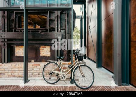 Innenraum der Fabrik Norblin mit Fahrrad, Fabryka Norblina - postindustrielle Architektur, neuer Teil der Stadt mit Büros. Geschäfte, Restaurants Stockfoto