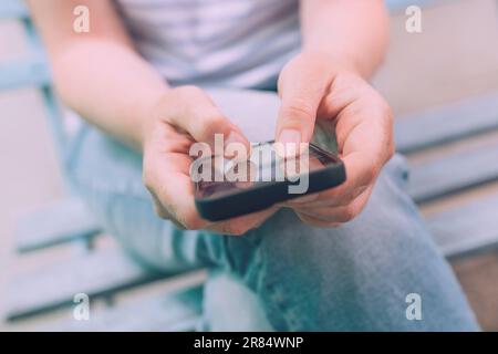 Angst vor dem Verfehlen (Fomo)-Konzept, Nahaufnahme weiblicher Hände mit dem Handy, selektiver Fokus Stockfoto