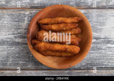 Chicken Nuggets auf einem Holzteller auf grauem Holzhintergrund. Draufsicht, flach liegend, Nahaufnahme. Stockfoto