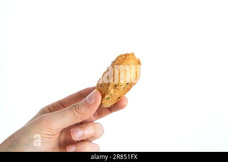 Kabeljauklößchen oder „Bolinho de bacalhau“, sehr berühmt in der portugiesischen Gastronomie. Gebratene Teigtaschen, Fisch, gesalzene Kabeljaufilets. Handgehaltener Kabeljaufutter. Stockfoto