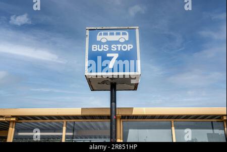 Blaues Bushaltestellenschild vor blauem Himmel am Flughafen, Shuttle-Bus. Stockfoto