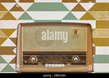 Oldtimer-Radio mit Display, auf dem europäische Städte vor einem Retro-Hintergrundbild dargestellt werden Stockfoto