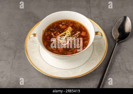 Heiße und saure Gemüsesuppe auf einem weißen Porzellanteller Stockfoto
