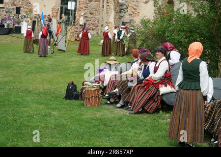 Dobele, Lettland - 27. Mai 2023. Menschen in ethnischen bunten Nationalkostümen feiern das traditionelle Kulturfest in der Nähe der Burgruinen von Dobele. Es ist nicht Stockfoto