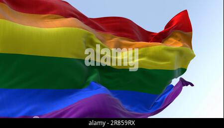 Die Regenbogenflagge winkt an klaren Tagen. Bunte Flagge mit Streifen in den Farben des Regenbogens, oft als Symbol des LGBT-Stolzes verwendet. 3D Abbildung Stockfoto