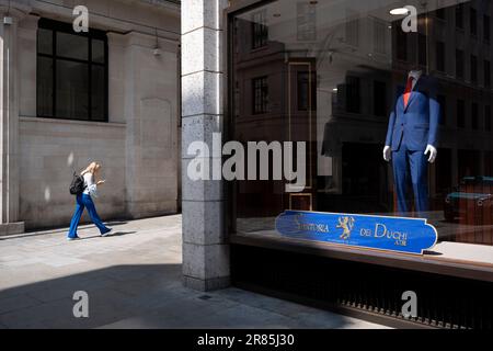 Eine Frau mit blauer Hose kommt am 19. Juni 2023 in London, England, an einer Puppe vorbei, die einen passenden blauen Anzug von Sartoria Dei Duchi in der Jermyn Street trägt. Stockfoto