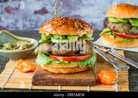 Plantain und Burger mit schwarzen Bohnen in Brioche-Brötchen Stockfoto