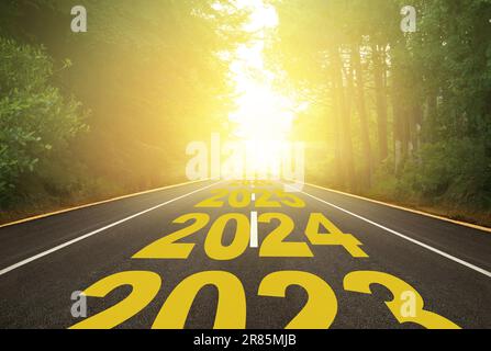 Das Wort 2024 auf einer Waldstraße. Konzept für das neue Jahr 2024-2027. Der Weg ins neue Jahr wird durch den Pfeil angezeigt. Jubiläumsvorbereitung Stockfoto