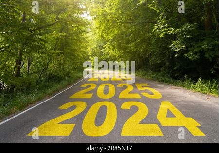 2024-2036 geschrieben auf einer Autobahn inmitten einer leeren, kurvigen Asphaltstraße und einem grünen Wald. Vision-Konzept 2024-2036. Neues Jahr beginnen Stockfoto