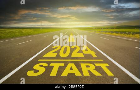 2024-Buchstaben auf leerer Asphaltstraße. Eine Straße auf dem Land, die geradeaus geht. Neujahrsstartziele 2024 Konzept Stockfoto