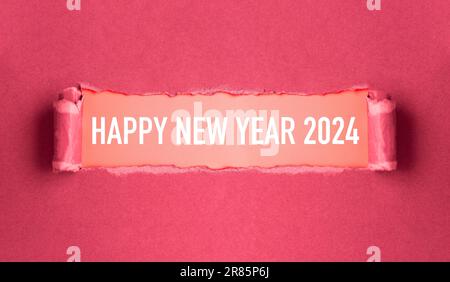 Neujahrskonzept. Zerrissener rosafarbener Karton mit der Aufschrift „Happy New Year 2024“ Stockfoto