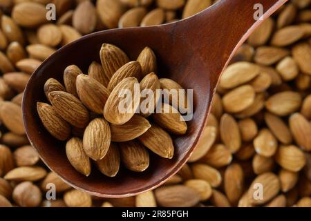 Geschälte Mandelkerne in einem Holzlöffel. Blick von oben. Gesunde Nuss. Stockfoto