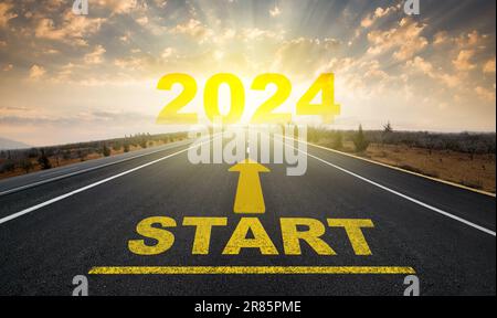 Beginn des neuen Jahres. Startlinie auf Asphaltstraße und 2024 Pfeil am Horizont. Neujahrskonzept. Stockfoto