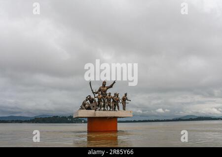 Guwahati, Indien. 17. Juni 2023. Dunkle Wolken schweben über der Statue von Lachit Borphukan, dem Kommandeur des Ahom-Königreichs am Brahmaputra River in Guwahati. Der Wasserstand des Brahmaputra River ist aufgrund starker Regenfälle in Guwahati gestiegen. Die starken Regenfälle verursachten auch Überschwemmungen in mehreren tief liegenden Teilen der Stadt. Kredit: SOPA Images Limited/Alamy Live News Stockfoto