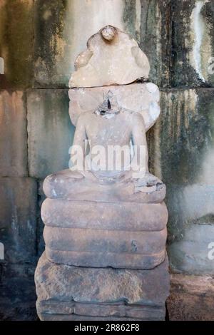 Eine kopflose Buddha-Skulptur, die in Lotusposition in einem kambodschanischen Tempel sitzt. Stockfoto