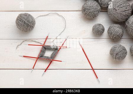 Der Strickvorgang im Kreis auf doppelseitigen Stricknadeln, Garnknäueln. Stockfoto