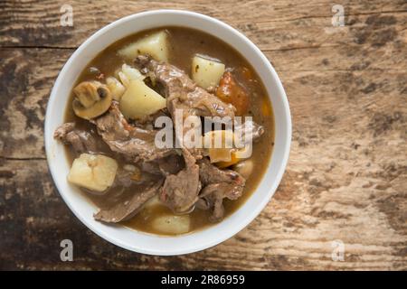 Ein hausgemachter Eintopf aus Wild eines Hirsches, Capreolus capreolus, der Zwiebeln, Karotten und Kartoffeln umfasst. England GB Stockfoto