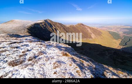 Der Gipfel von Hopegill Head auf der linken Seite über Hobcarton Crag und Hobcarton im Tal darunter im Winter im englischen Lake District, Großbritannien. Stockfoto