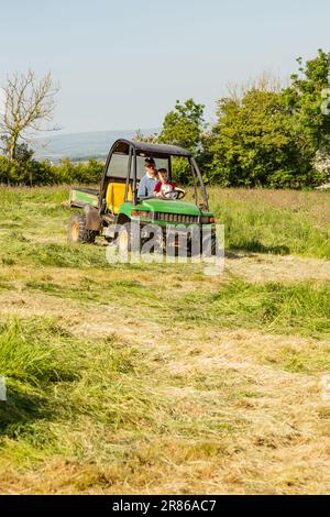 Sechs Jahre alter Junge, der einen John Deere Gator, High Bickington, North Devon, England, Großbritannien, taucht. Stockfoto