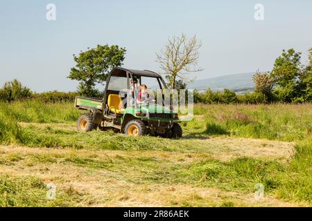 Sechs Jahre alter Junge, der einen John Deere Gator, High Bickington, North Devon, England, Großbritannien, taucht. Stockfoto