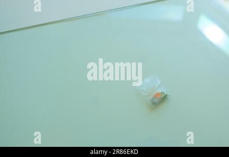 Ein Beutel mit Tesla Ecstasy-Pillen in Orange, Grün und Blau in Form eines Schilds mit dem Tesla Logo; 240 Milligramm MDMA Molly für die Freizeit. Stockfoto