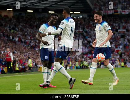 Bukayo Saka (links) aus England feiert mit Marcus Rashford (Mitte) und Declan Rice das fünfte Tor ihrer Seite im Spiel und vervollständigt seinen Hattrick während des UEFA Euro 2024 Qualifying Group C-Spiels in Old Trafford, Manchester. Foto: Montag, 19. Juni 2023. Stockfoto