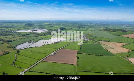 Kumbrianisches Ackerland im Frühjahr mit einem Flickenteppich aus Feldern und Kulturen. In der Nähe von Penrith, Großbritannien. Stockfoto