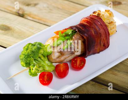 Geröstete Wachteln in Schinken mit Gemüse verpackt Stockfoto