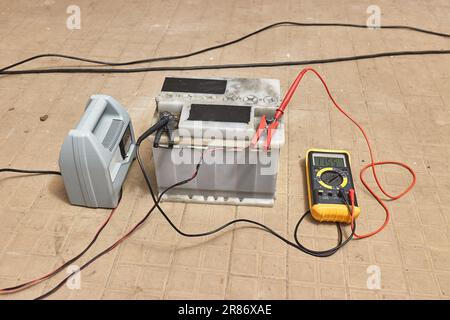 Laden einer Starterbatterie in einer Garage Stockfoto