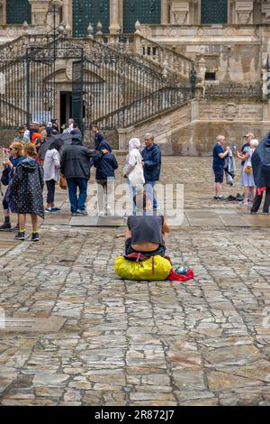 Santiago de Compostela, La Coruna, Galicien, Spanien - 11. Juni 2023. Pilgerfrau, die vor der Kathedrale von Santiago de Compostela ruht Stockfoto