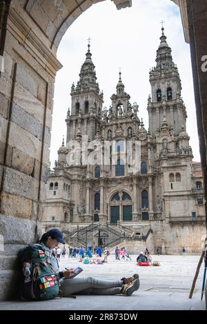 Junge Pilgerin, die ein Buch in Santiago de Compostela, La Coruna, Galicien, Spanien liest. Stockfoto