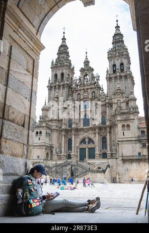 Junge Pilgerin, die ein Buch in Santiago de Compostela, La Coruna, Galicien, Spanien liest. Stockfoto