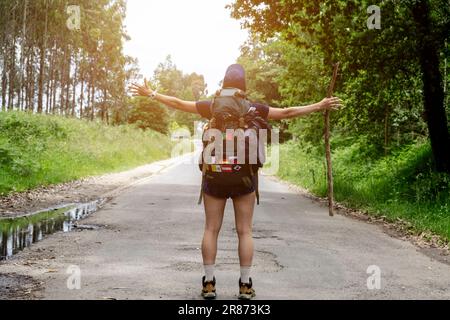 Eine junge Pilgerfrau feiert auf einem Weg des heiligen james. Camino de Santiago. Leistungskonzept Stockfoto