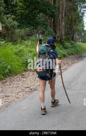 Eine junge Pilgerin, die ein Selfie auf dem Weg des heiligen james macht. Camino de Santiago. Vertikaler Schuss. Stockfoto